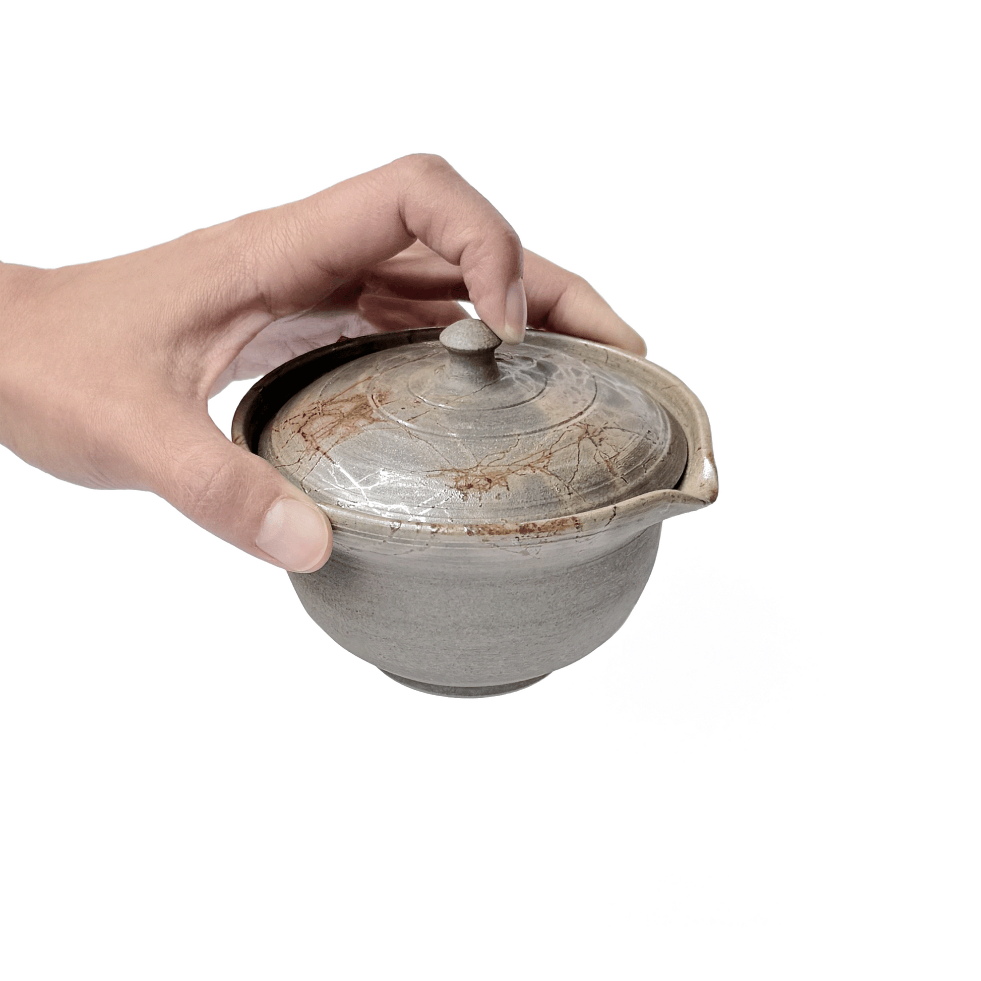 Hand holding Akikusa Shiboridashi teapot with the lid on