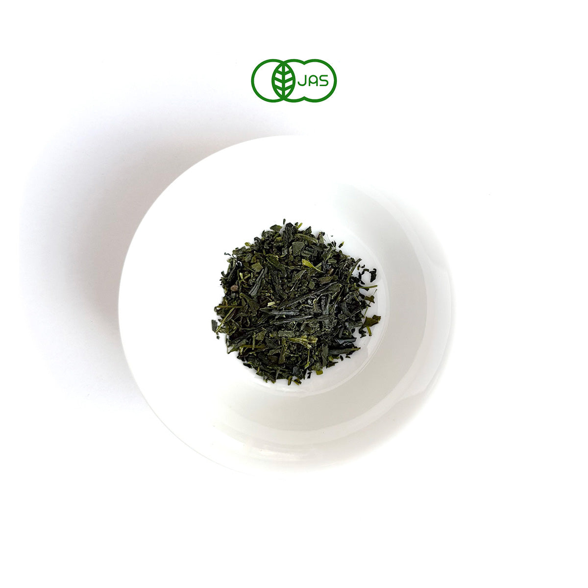 ICHOU Green tea leaves in a white bowl on a white background