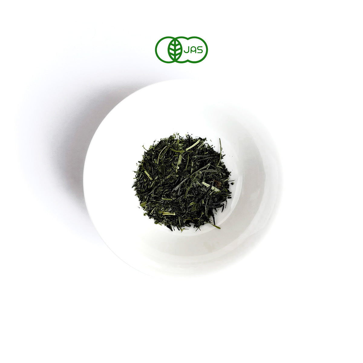 TSUTA Green tea leaves in a white plate on a white background