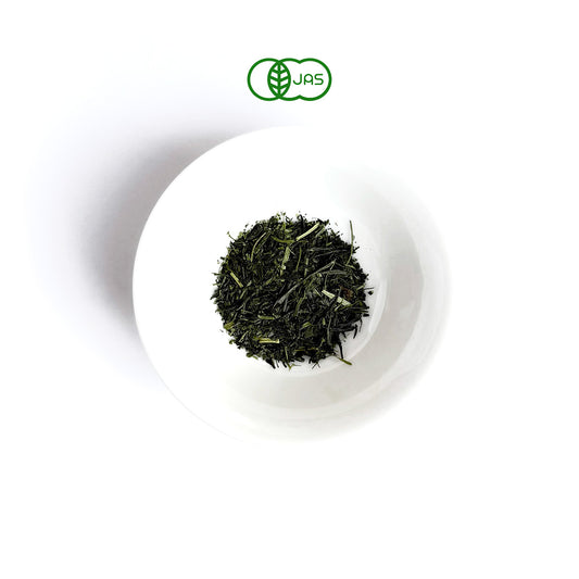 TSUTA Green tea leaves in a white plate on a white background
