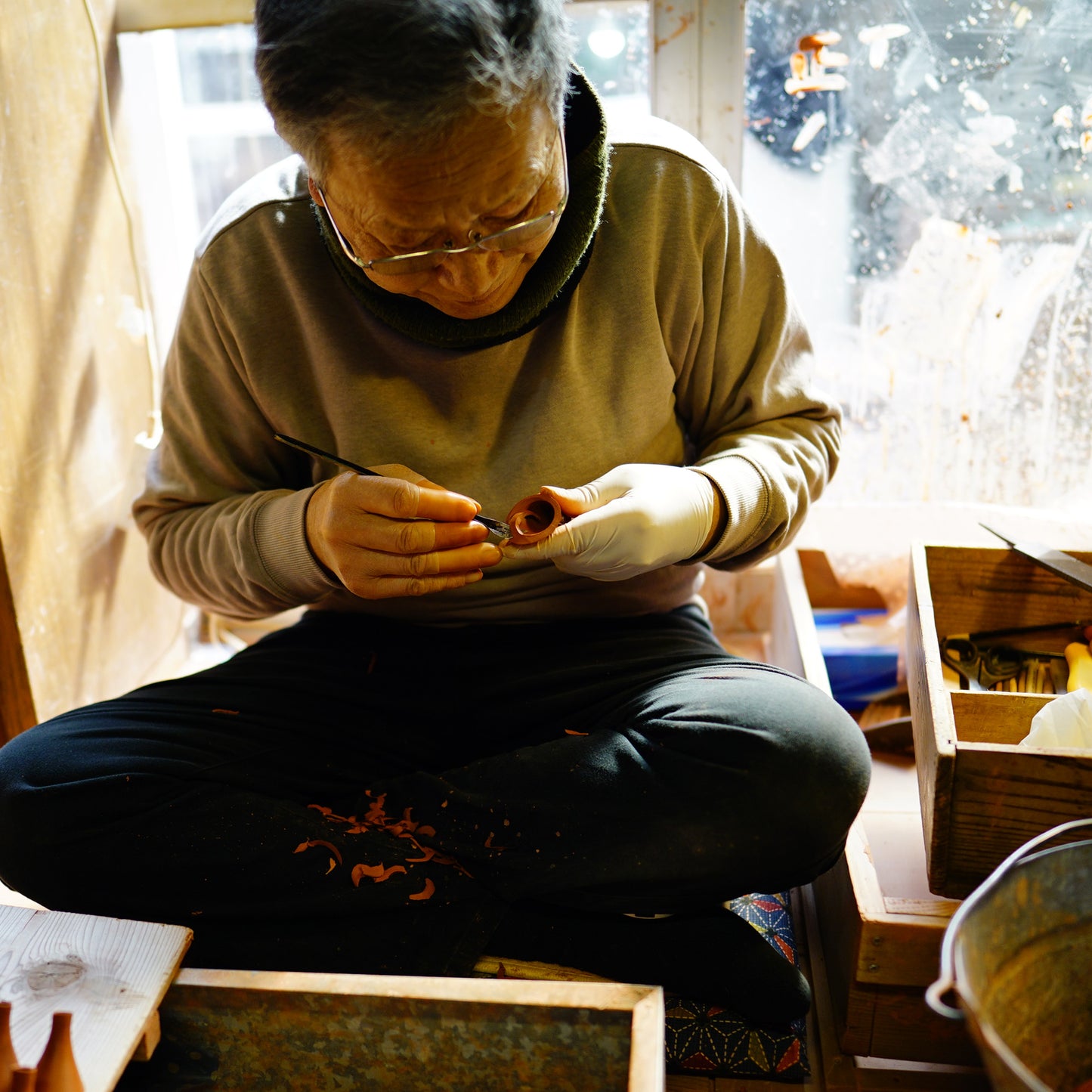 Artisan working on teapot in a workshop setting