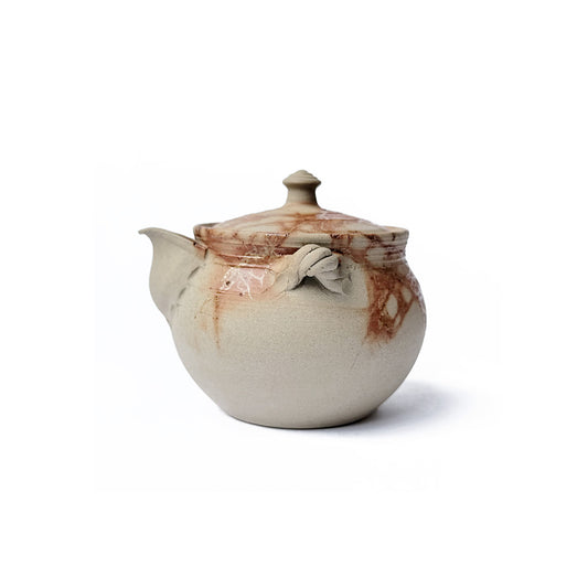 Ceramic teapot with organic fire mark on a white background