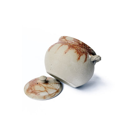 Bottom of a Ceramic teapot with organic fire mark on a white background