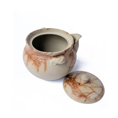 Ceramic teapot with organic fire mark with the lid on its side