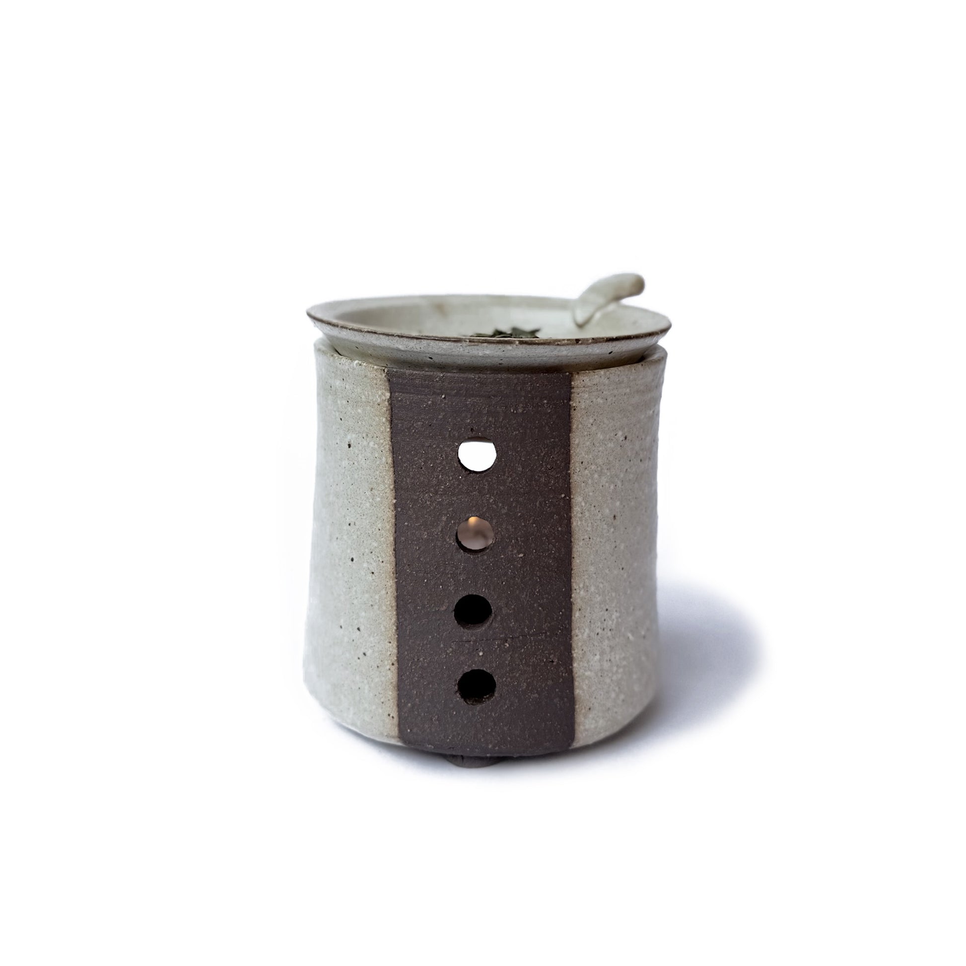 The back of a Charkoro tea diffuser with a small dish on top