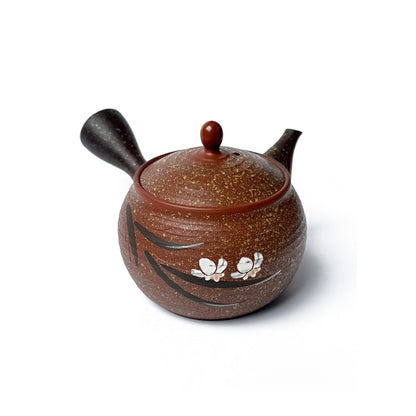 A brown speckled ceramic teapot with a dark brown handle and spout, decorated with black brushstrokes and three white blossoms on the front, set against a plain white background.