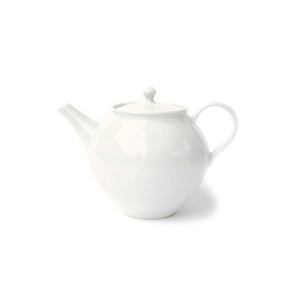 A white ceramic teapot with a textured surface finish, featuring a rounded body, a curved spout, and a loop handle, set against a plain white background.