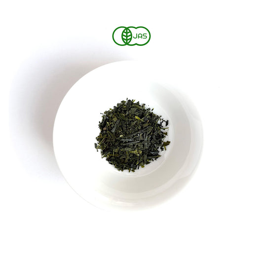 ICHOU Green tea leaves in a white bowl on a white background