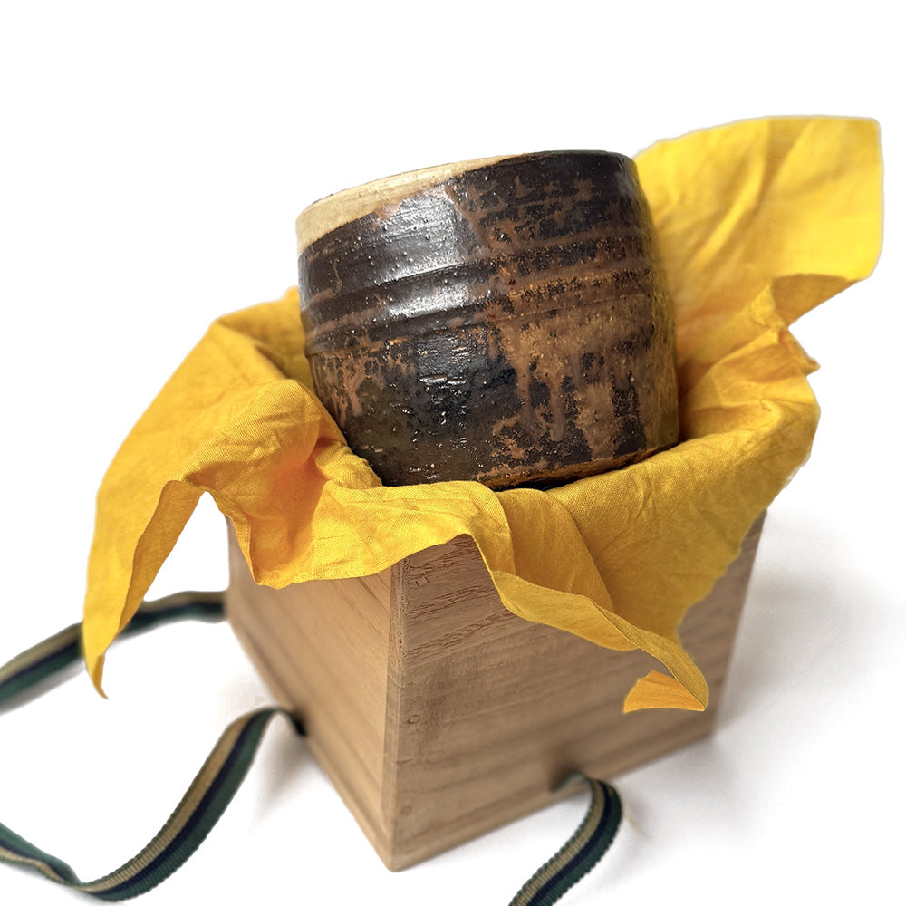 Traditional handmade tea bowl inside  its original matching on yellow fabric