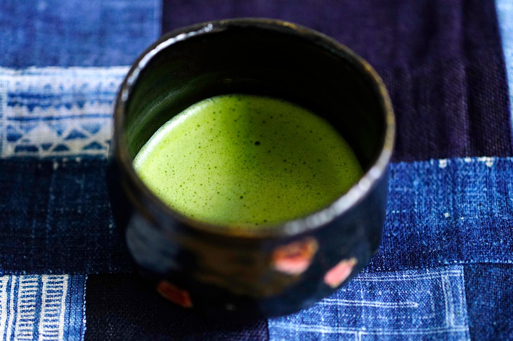 Cup of matcha on a blue patterned fabric