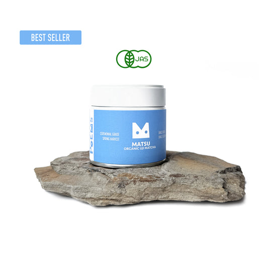 Matsu Organic Matcha container on a rock with a visible brand logo.