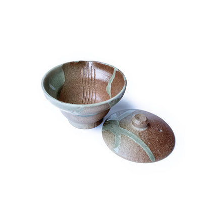 Ceramic Shiboridashi and lid with brown and green glaze on a white background
